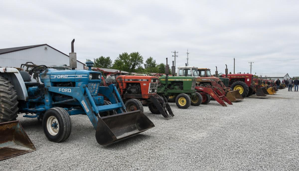 A row of used tractors lined up at a farm auction